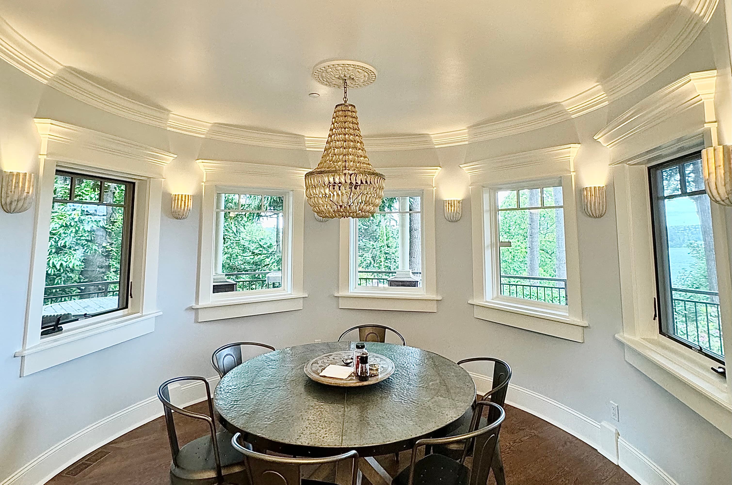 Round dining room with beaded chandelier and panoramic windows